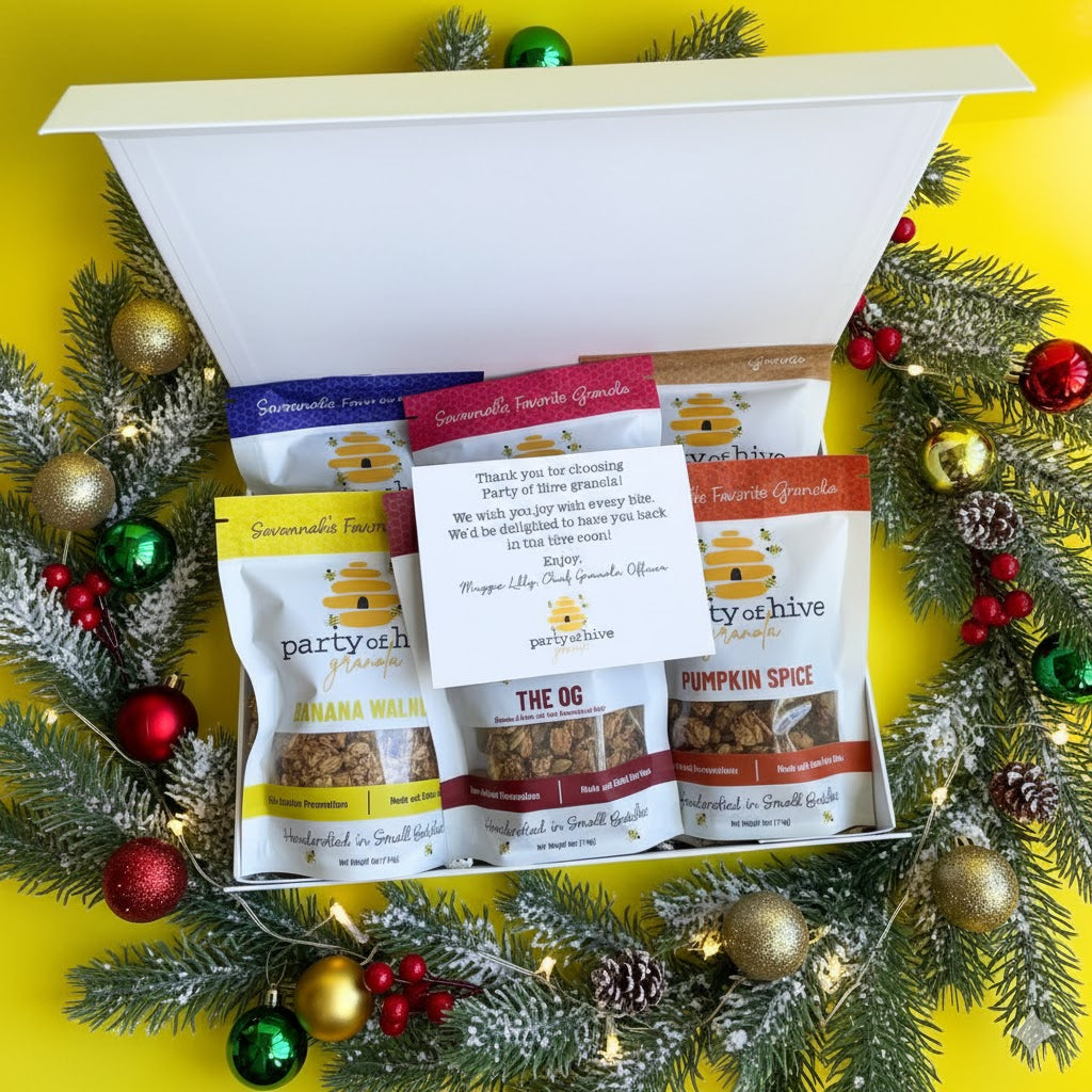 Assorted snack packages in a decorative box with Christmas decorations on a yellow background